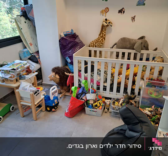 חדר ילדים עם צעצועים מאורגנים בסלים ליד מיטת תינוק
